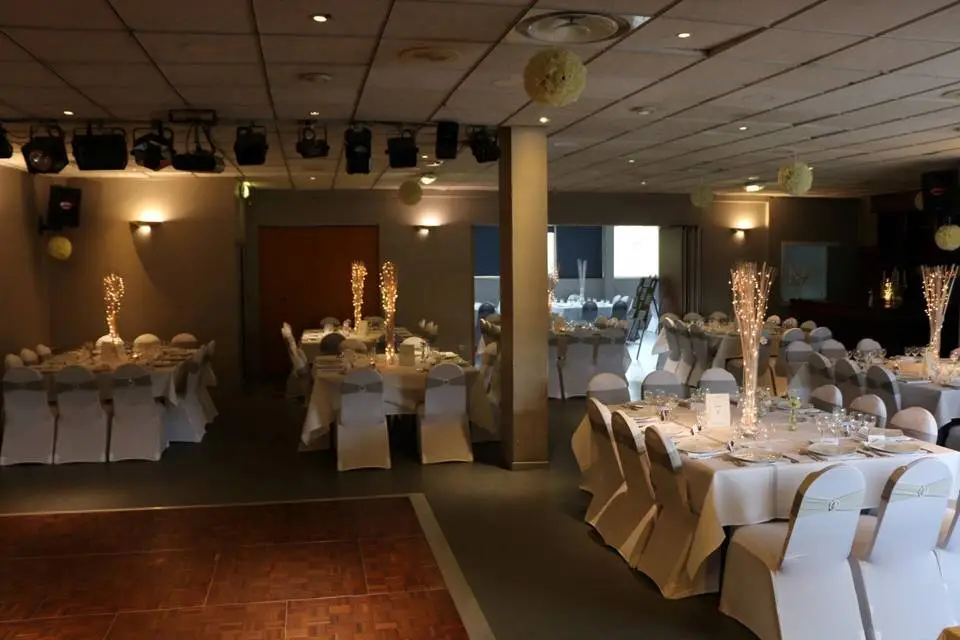 Vue panoramique de la salle de réception, révélant l'éclairage chaleureux et l'aménagement spacieux